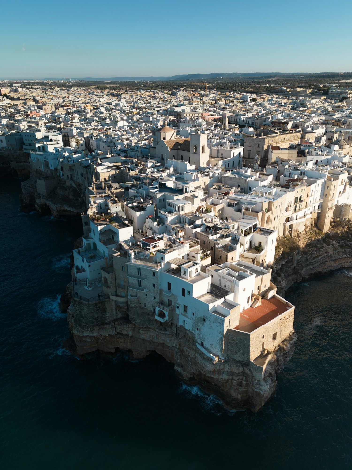 Aerial view of Polignano a Mare, its white houses perched on the Adriatic cliffs.